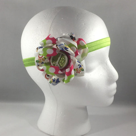 Stitched Headband for a child age 12-18 mos.  Pretty Disney Ribbon and Hot ink and Green Ribbon Bow is on a hair-clip so it can be worn without the green headband.