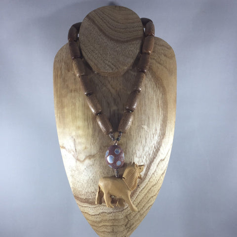 Wooden cylinder beads strung on wire with hand carved lion focal.  Oval flat back stone wit inlay.  Matching earrings included.  Necklace 18"