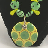 Necklace, Green striped and spotted ceramic and yellow duckbill beads