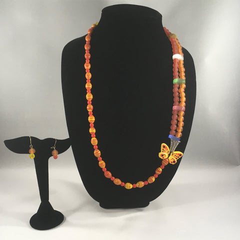Orange round beads, yellow stripped beads, and Butterfly embellishment.  Brass yellow clasp.  Necklace measures 28" around.  Earrings included.