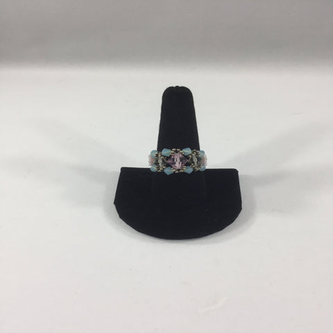 Beaded Ring with Pink Swarovski Bicone with Turquoise Swarovski accents bicones.  Crystal White Glass Seed Bead Band. Size 9 1/2. Although this ring is strung with Fireline, constant exposure to water is not recommended.