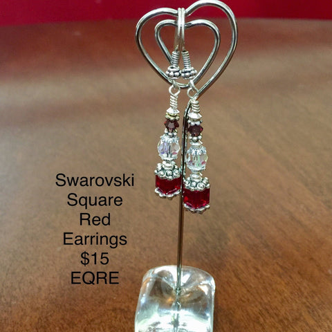 Pierced Earrings with a Red Swarovski Cube Bead, a Crystal Swarovski Round Bead and a Red Swarovski Bicone Bad. Sterling Silver findings and Ear Wires.