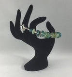 This stunning Greens and Blues bracelet is made up of all Lamp Work beads and Sterling Silver spacers.  Some of the Lamp Work beads have Frit on them.  The clasp is also Sterling Silver.  Size 8.25