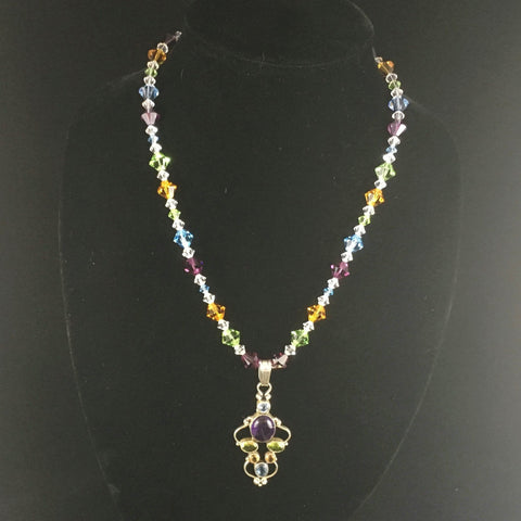 "Peri's Amber:. The AB crystal Swarovskis make this necklace absolutely shimmer!  The other colors are also Swarovski's Peridot, Topaz, Aquamarine, and Amethyst. Earrings included.  The necklace is 20" and the Sterling encased Pendant is 3"